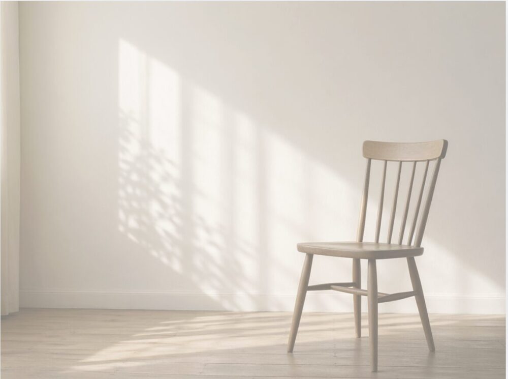 自然光が差し込む部屋に置かれた木の椅子。人のいない静かな空間。