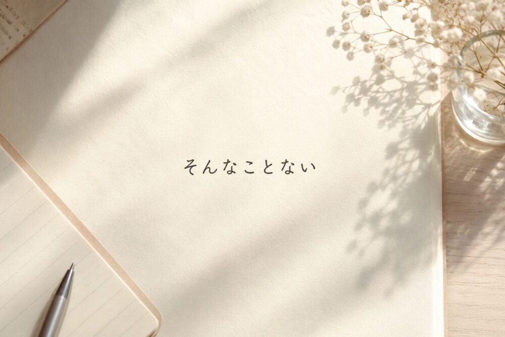 やわらかな朝の光が差し込む机の上。ノートやペン、かすみ草が置かれた静かな空間の中央に、「そんなことない」という文字が書かれている。